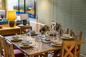 Elegant dining table set with plates, glasses, and cutlery in Highland Club Scotland.
