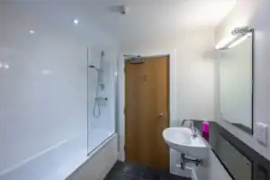 Bathroom with bathtub, shower, and sink at Highland Club Scotland development.