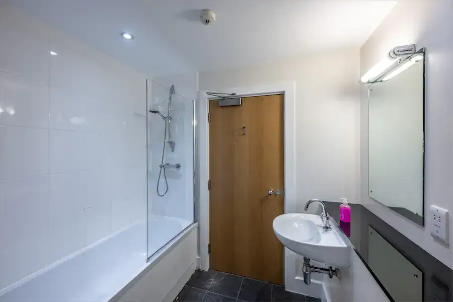 Bathroom with bathtub, shower, and sink at Highland Club Scotland development.
