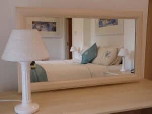 Elegant bedroom with mirror, lamps, and cozy decor at Highland Club Scotland.