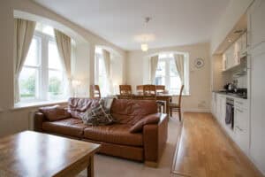 Spacious living room with large windows and natural light at Highland Club Scotland.