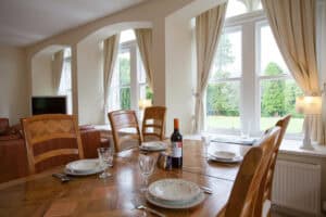 Elegant dining room with large windows and wooden furniture at Highland Club Scotland.