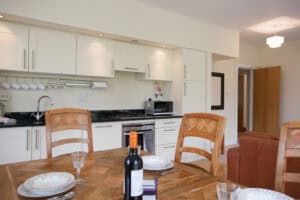 Spacious kitchen with white cabinets, black countertops, and contemporary appliances.