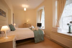 Highland Club Scotland bedroom with comfortable bed and natural light.
