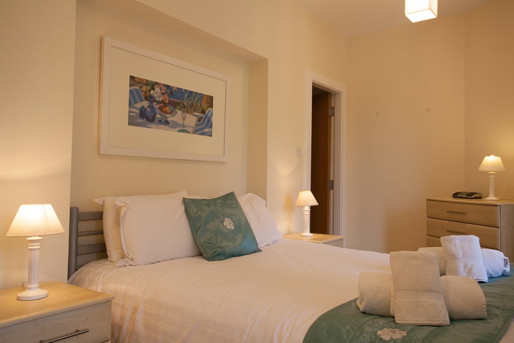 Elegant Highland Club Scotland bedroom with comfortable bed and soft lighting.