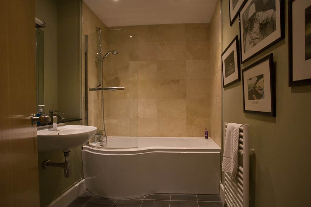 Bathroom with bathtub and shower, featuring modern fixtures and neutral decor at Highland Club Scotl.