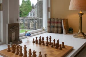 Chess set on a windowsill with a view of historic buildings at Highland Club Scotland.