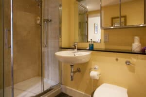 Modern bathroom with shower at Highland Club Scotland development, featuring contemporary fixtures a.