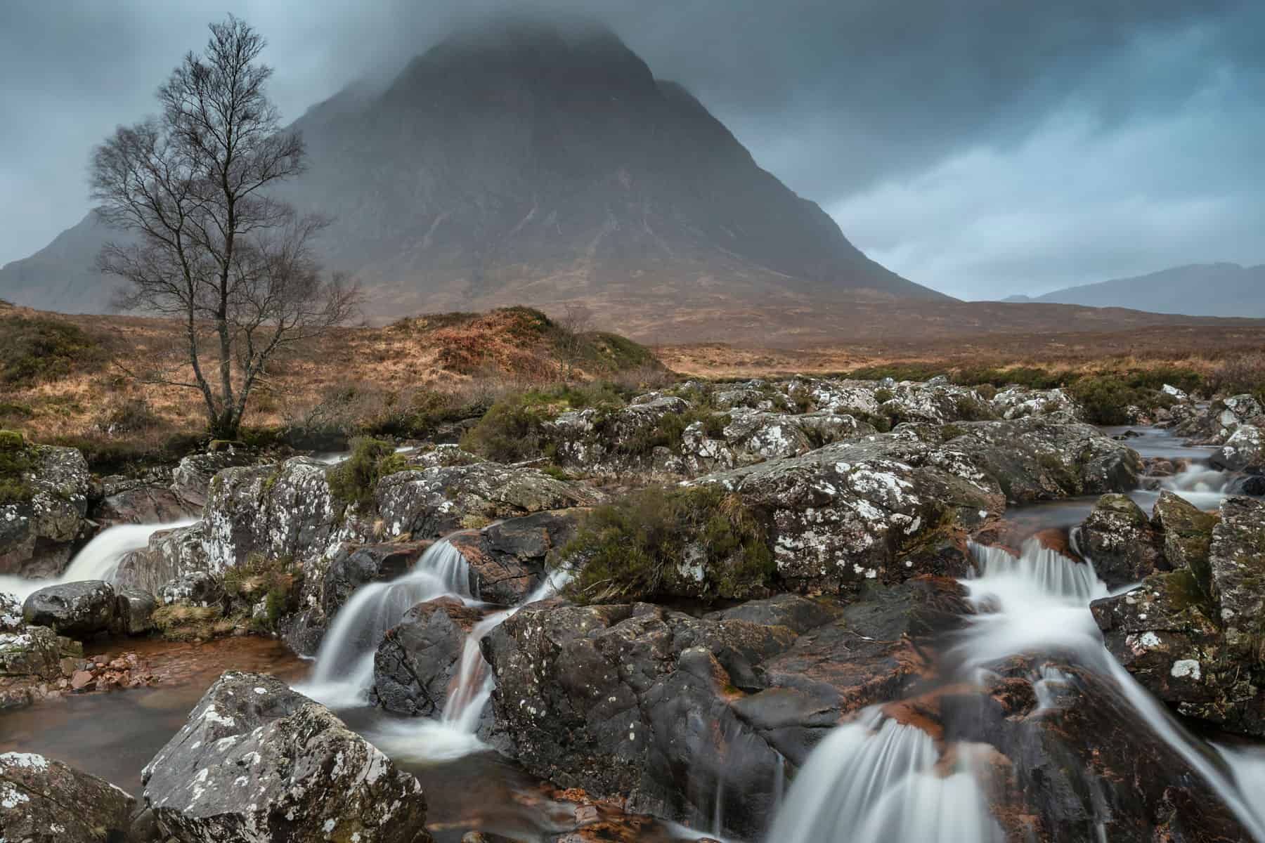 Scenic Highland landscape with mountain, river, and rocks in Scotland.