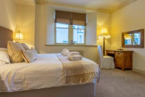 Cozy bedroom in Highland Club with comfortable bed and warm lighting.