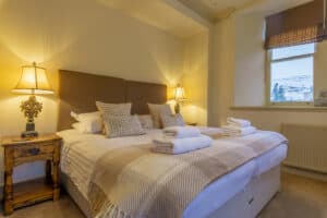 Elegant bedroom with comfortable bedding and scenic window view.