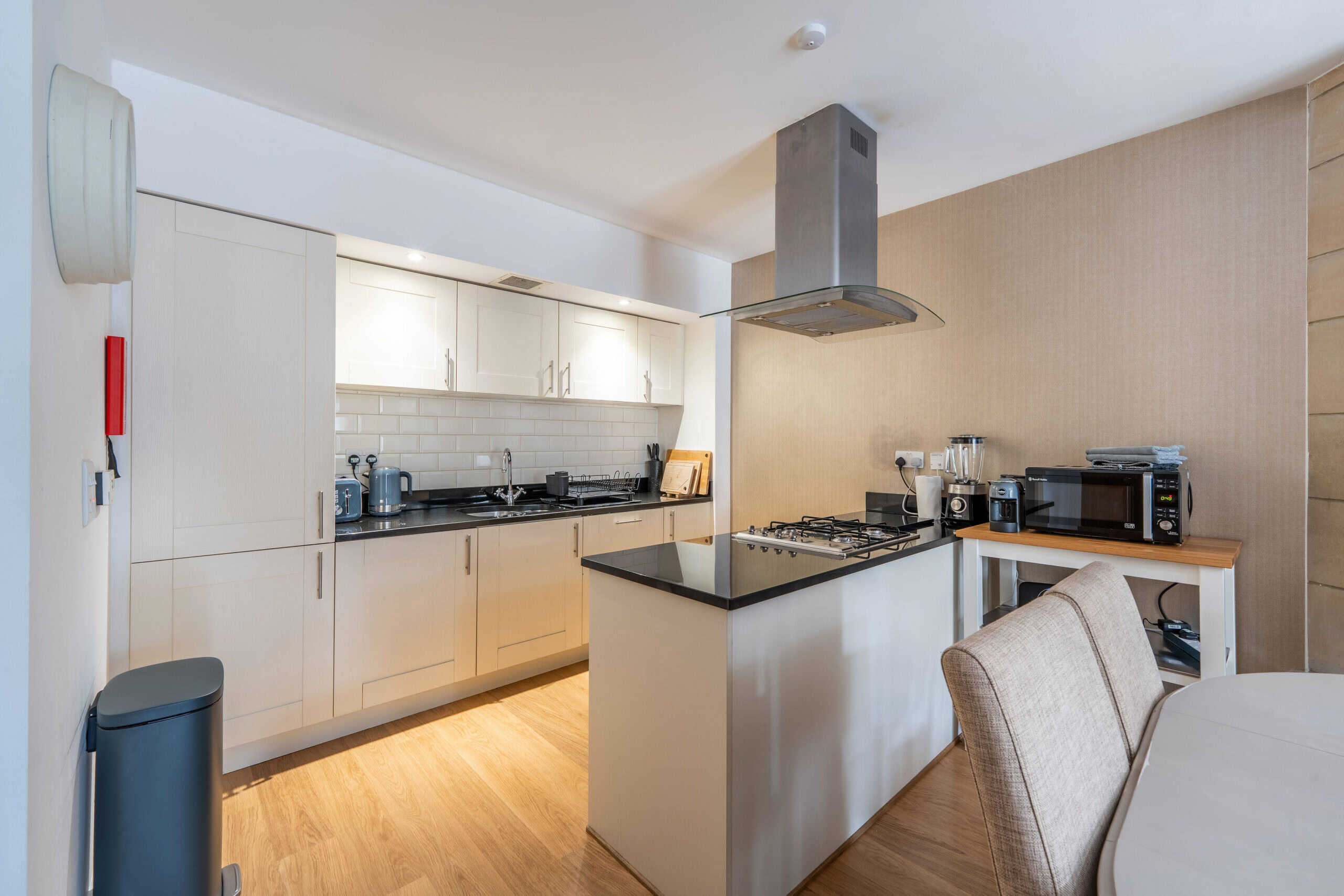 Contemporary Highland Club kitchen with white cabinets and modern appliances.