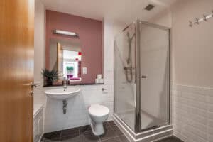 Bathroom with shower, toilet, and sink at Highland Club Scotland residential development.