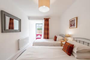 Bright Highland Club guest room with twin beds, colourful curtains, and modern decor.