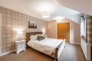 Comfortable bedroom at Highland Club with warm decor and natural light.