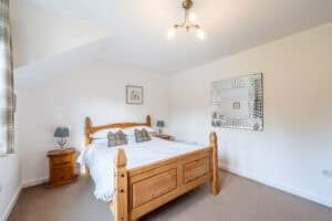 Bedroom with wooden bed and modern decor at Highland Club Scotland.