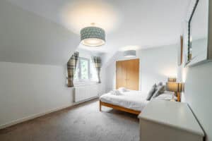 Modern bedroom at Highland Club Scotland with cosy decor and natural light.