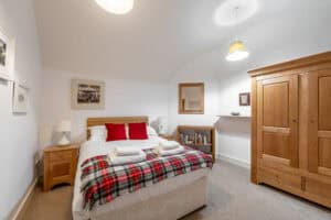 Bright Highland Club bedroom with wooden furniture and cosy decor.
