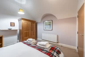 Comfortable Highland Club bedroom with wooden furniture and cosy decor.