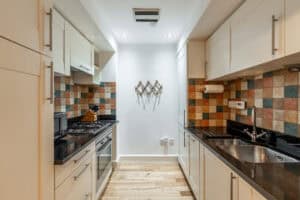 Modern Highland Club kitchen with colourful tiled backsplash and sleek cabinetry.