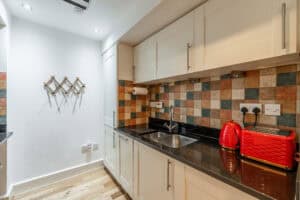 Contemporary kitchen with colourful tiled backsplash and modern appliances.