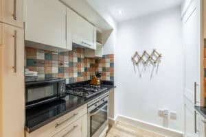Highland Club Scotland kitchen with colourful tiled backsplash and modern appliances.