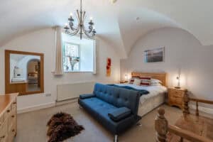 Modern bedroom with vaulted ceiling and elegant decor.