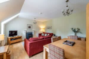 Highland Club Scotland living room with comfortable red sofa and wooden furniture.