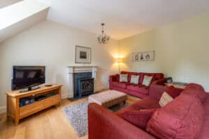 Cozy Highland Club Scotland living room with comfortable sofas and a fireplace. Perfect for relaxing.