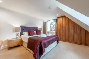 Luxury Highland Club bedroom with modern furnishings and scenic window views.