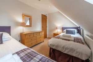 Bright Highland Club guest bedroom with two beds and modern decor.
