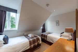 Comfortable Highland Club guest room with twin beds and natural light.