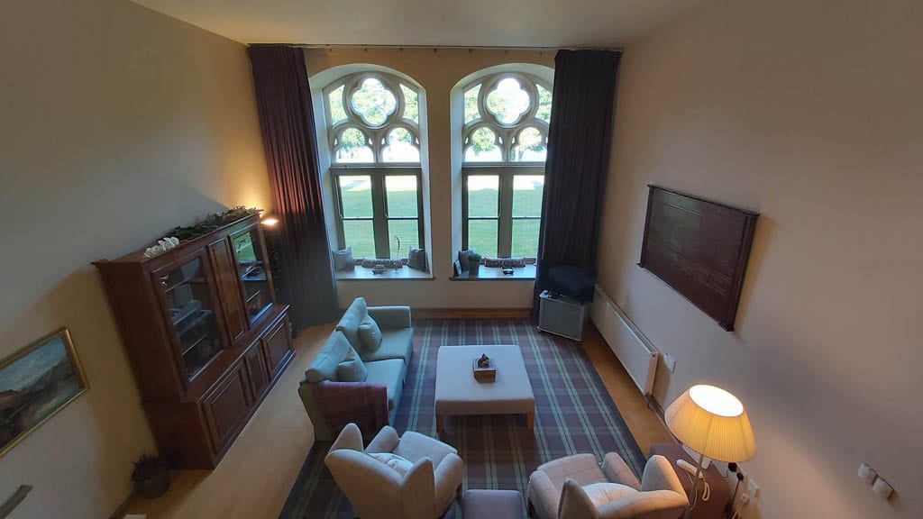 Lounge area with large arched windows and comfortable seating at Highland Club Scotland.