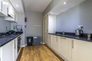 Modern kitchen with white cabinets and black countertops at HCS Development, Highland Club Scotland.