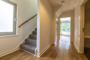 Bright hallway with wooden flooring and natural light from large windows in Highland Club Scotland d.