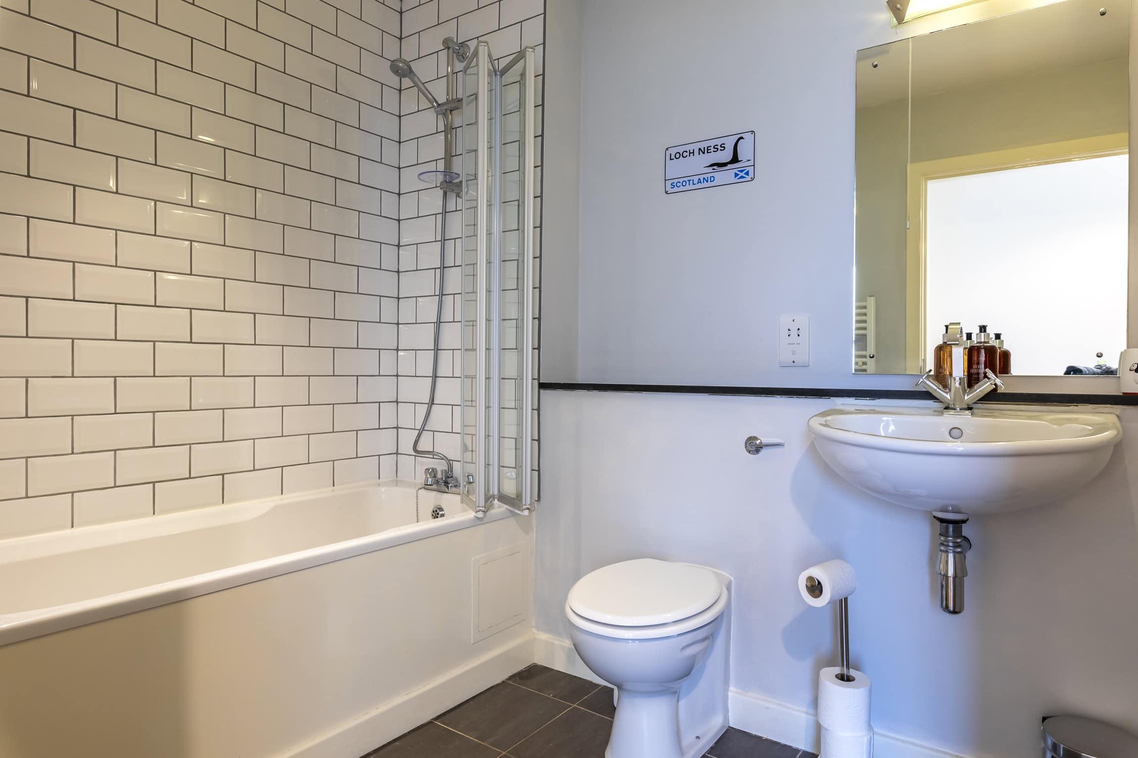 Modern bathroom with bathtub, toilet, and sink at Highland Club Scotland development.