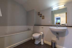 Modern bathroom with bathtub, toilet, and sink in Highland Club Scotland development.