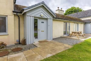 Highland Club Scotland residential building with modern entrance and outdoor seating area.
