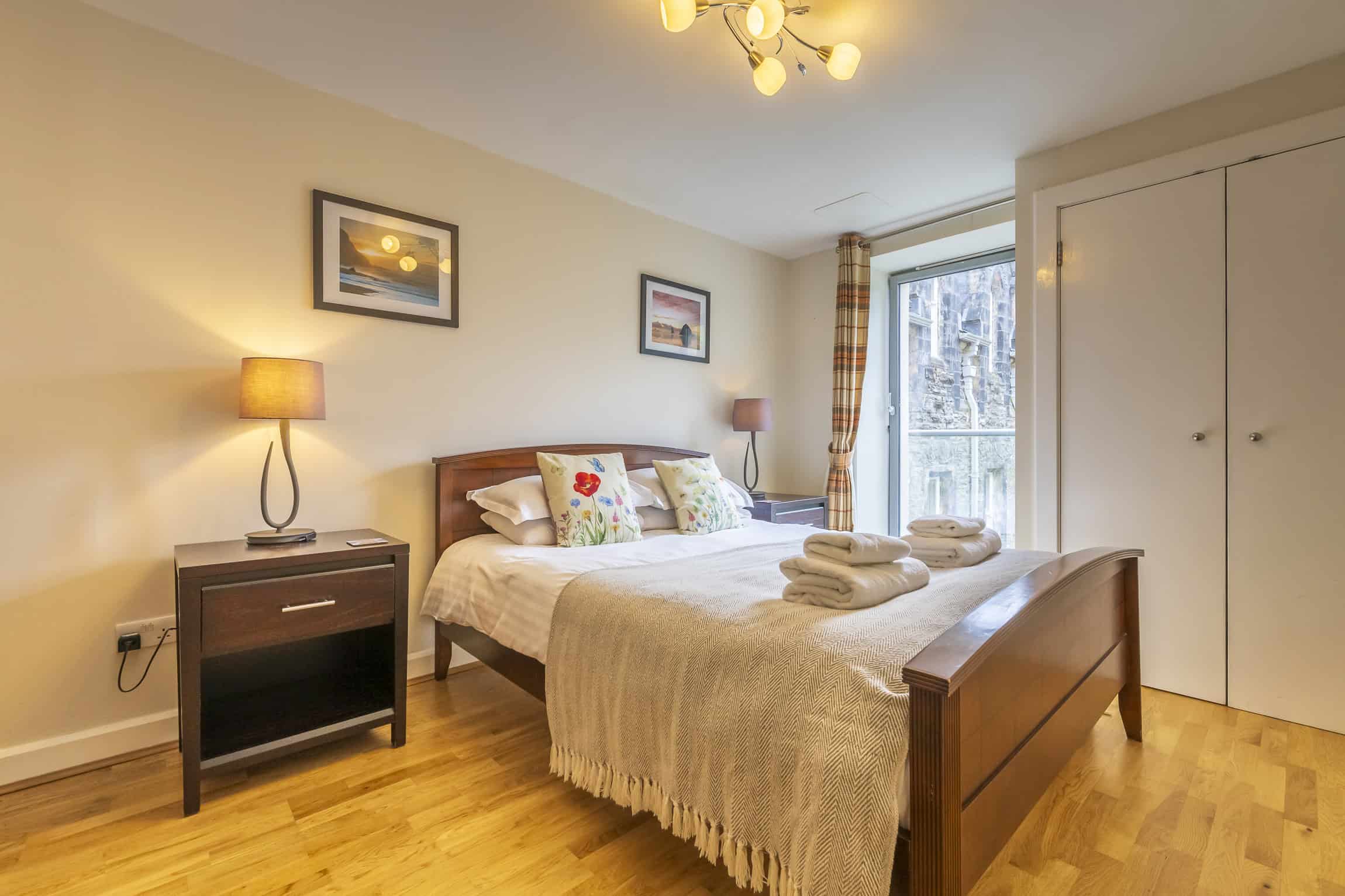 Modern bedroom with wooden furniture and cosy decor at Highland Club Scotland.