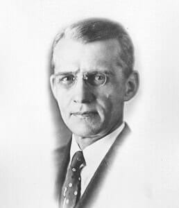 ChesterMontgomery A historical black and white portrait of a man in formal attire and glasses.