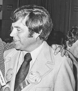 JerryMiller Black and white photo of a man in a suit with badges, attending a historical or museum event.