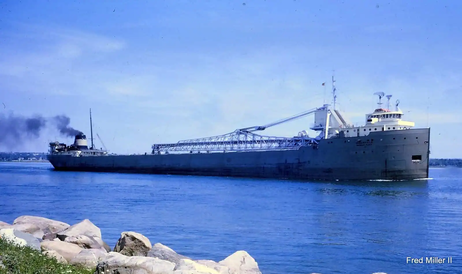 A historic cargo ship navigating calm waters, showcasing maritime history and naval architecture.