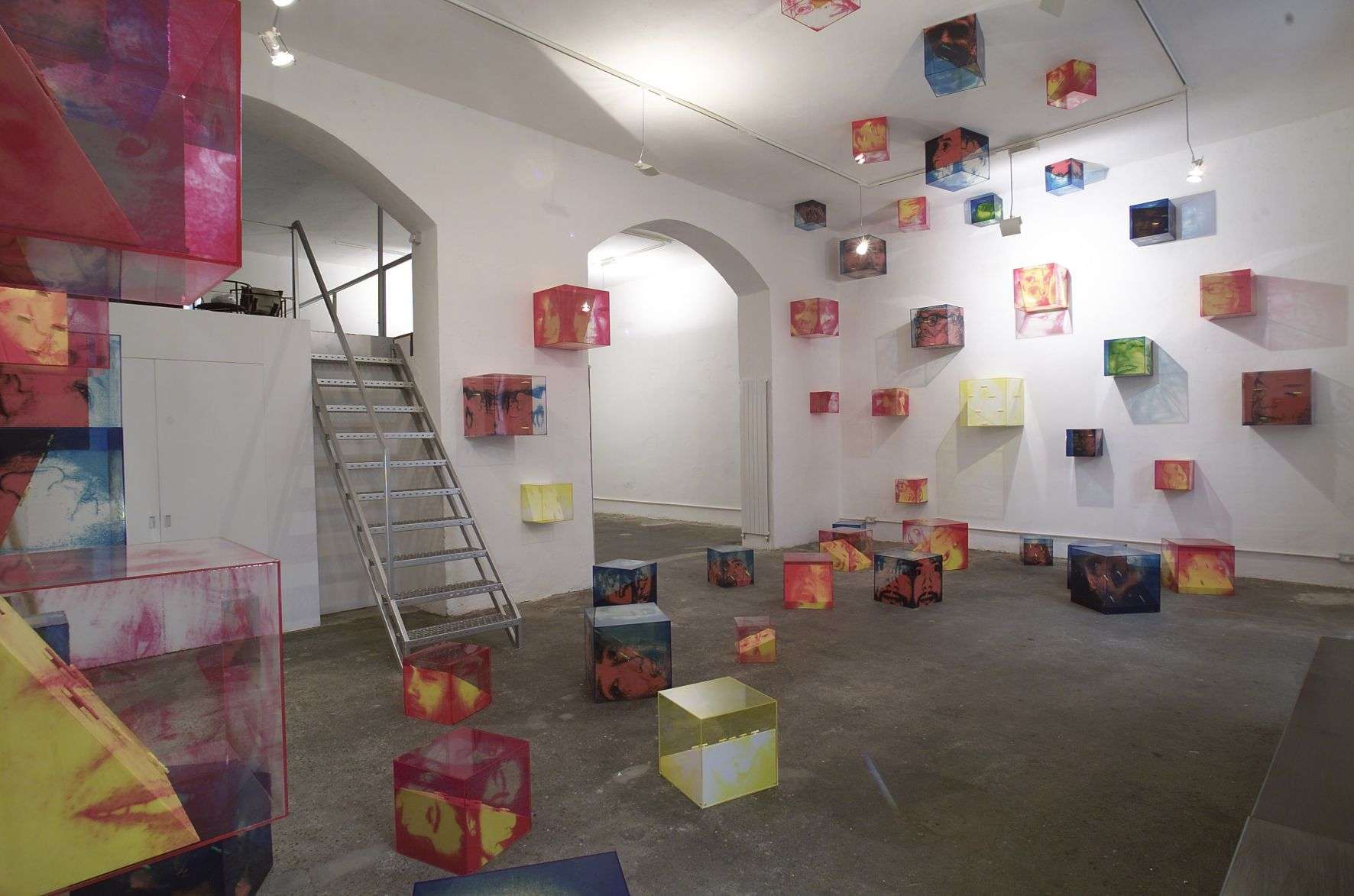 Colorful cube sculptures in modern art gallery space.