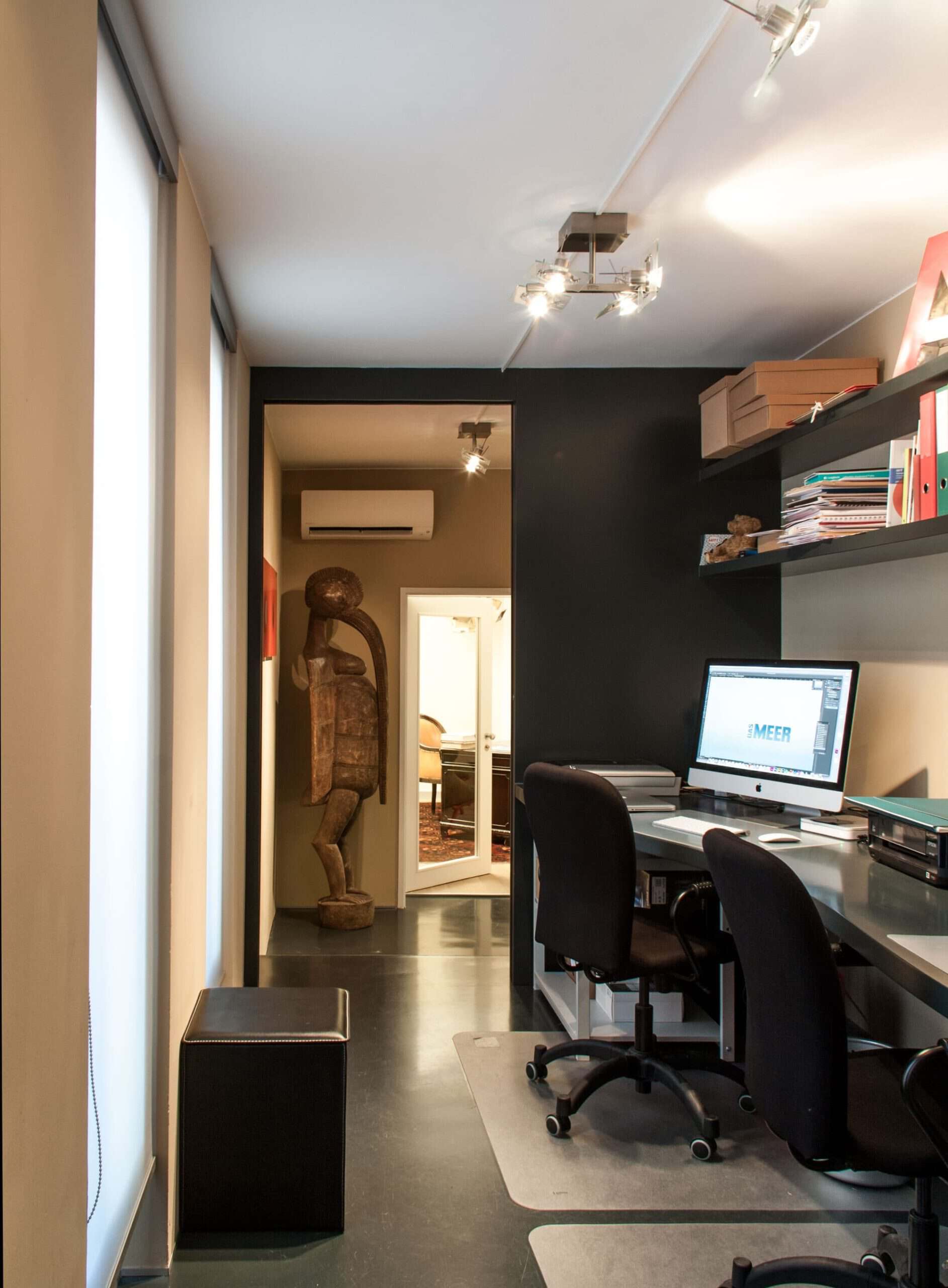 Modern home office with black accent wall and workspace setup.
