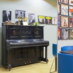 Interior Of A Modern Room With A Black Piano And Colorful Wall Art.