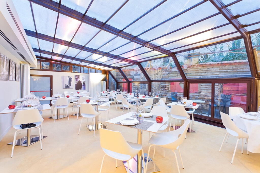 Elegant restaurant interior with glass ceiling and modern decor in Milan.