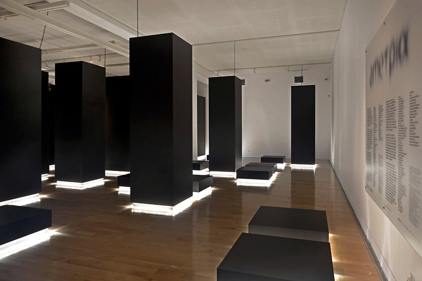 Modern interior with black display panels and wooden flooring at arcHITects srl.