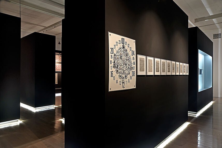 Modern art gallery interior with black walls and framed artworks.