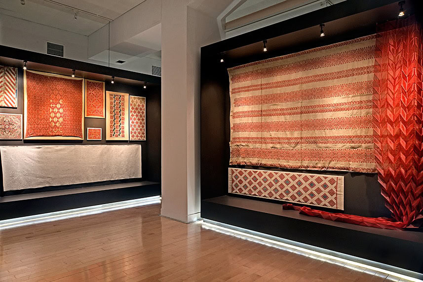Exhibition of red and patterned textiles at arcHITects srl in Ametria.