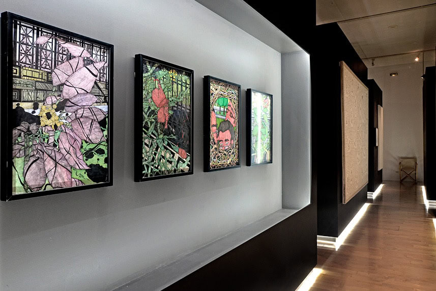Contemporary art display with colorful stained glass artworks in a modern gallery.
